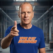 Man wearing a blue Christmas movie t-shirt with colorful text 