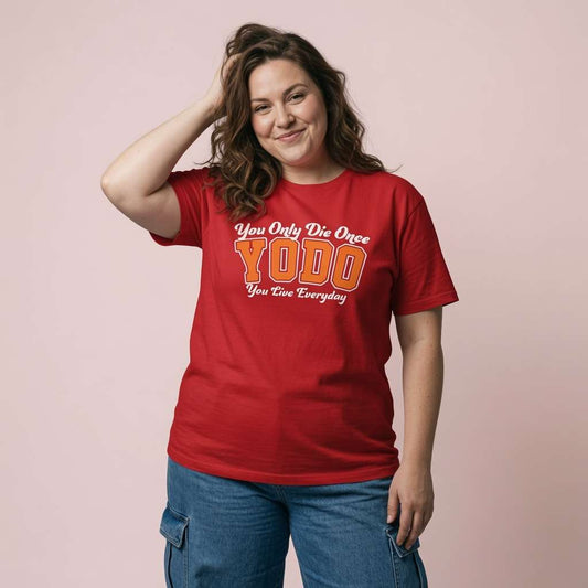 Woman smiling with one hand in her hair while wearing a red YODO t-shirt, fun ladies positive slogan design