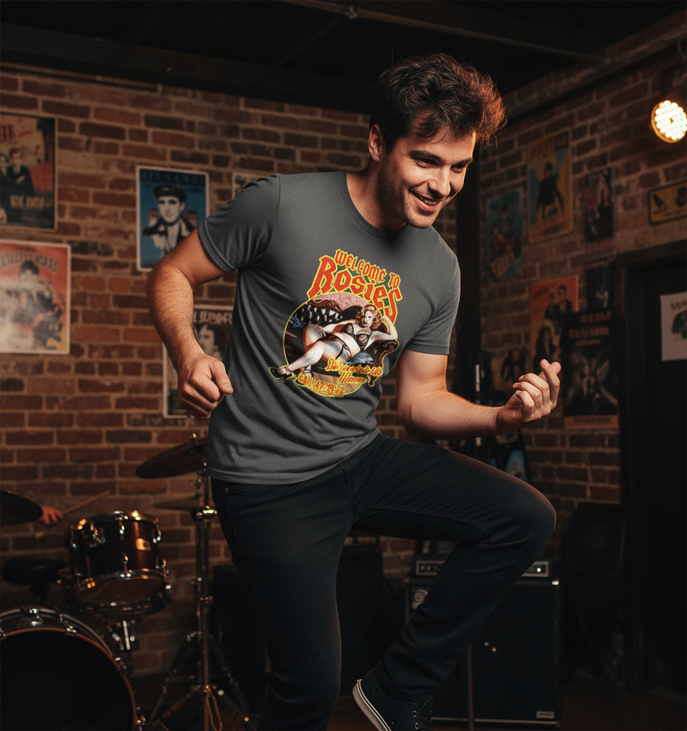 Man wearing a t-shirt with a graphic design in a room with brick walls and posters.