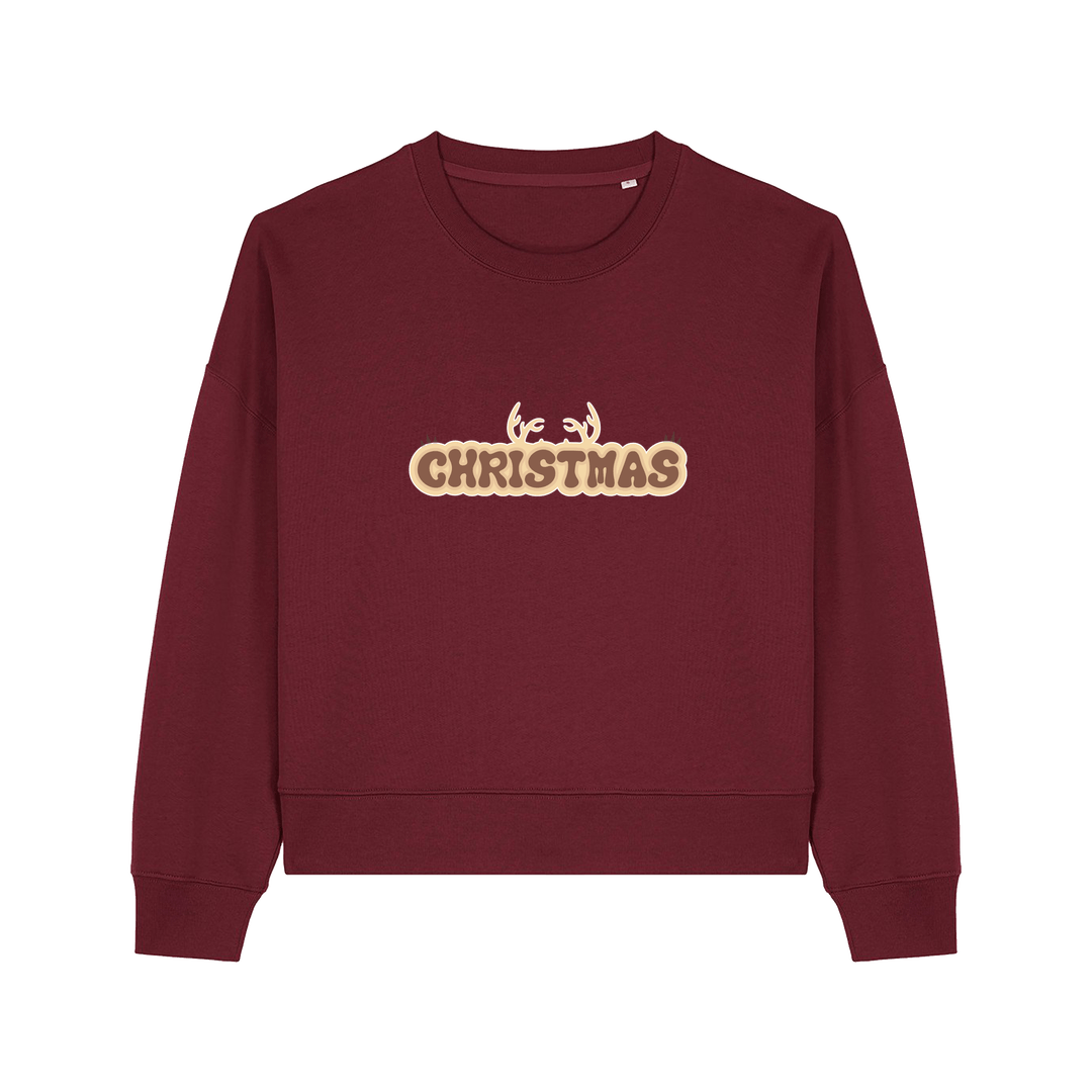 burgundy christmas sweater with the slogan 'christmas' and antlers poking out of the top