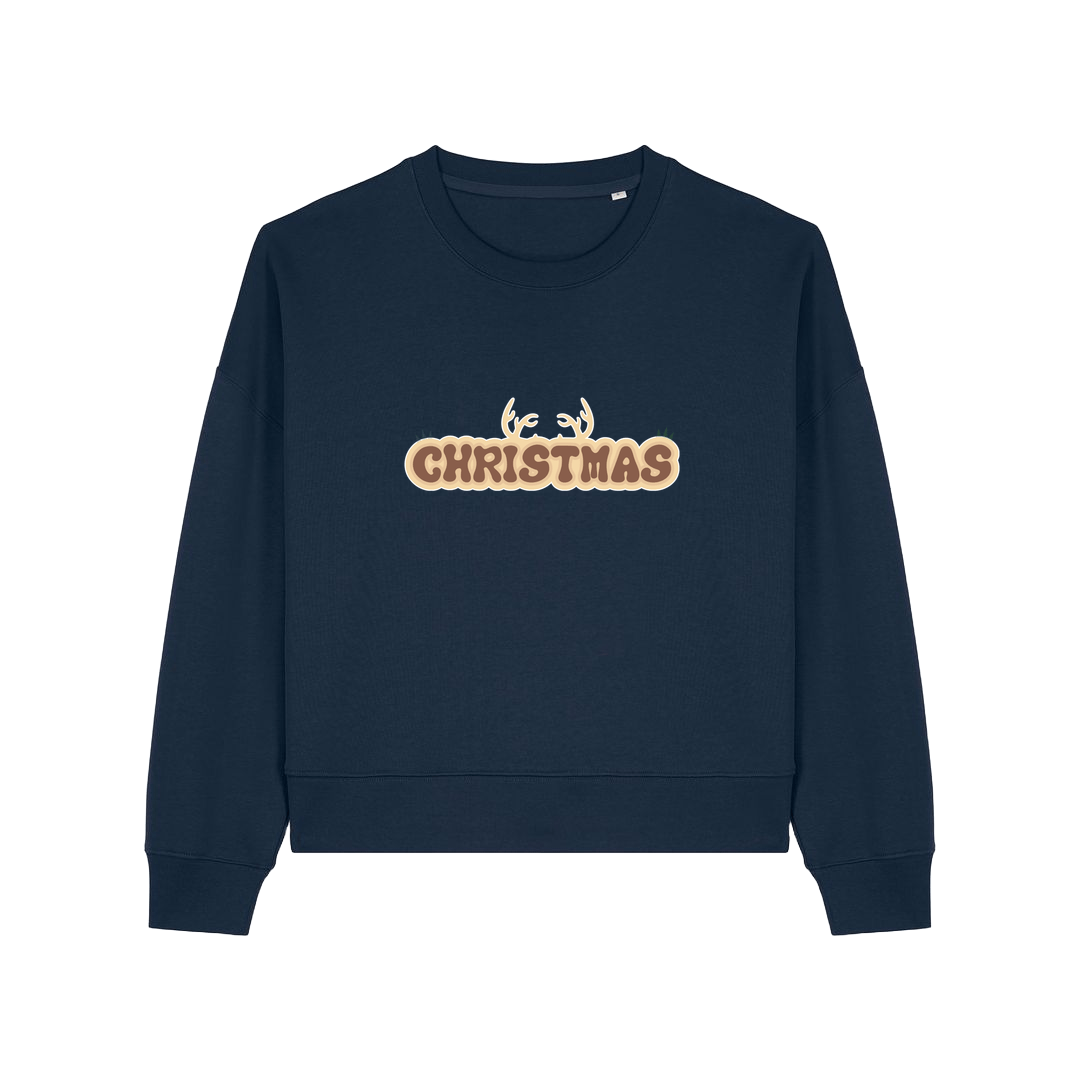 navy christmas sweater with the slogan 'christmas' and antlers poking out of the top