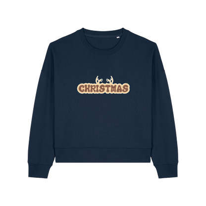 navy christmas sweater with the slogan 'christmas' and antlers poking out of the top
