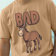 Beige funny t-shirt with a humorous cartoon ass and 'BAD' slogan on a light blue background