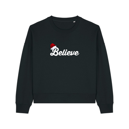black christmas sweater with the slogan 'believe' and a santa hat on top of the b
