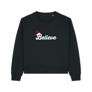 black christmas sweater with the slogan 'believe' and a santa hat on top of the b