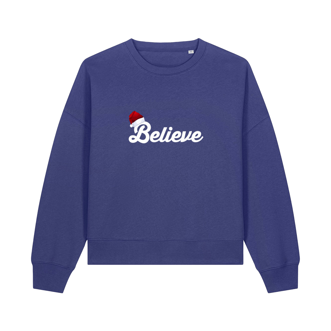 blue christmas sweater with the slogan 'believe' and a santa hat on top of the b