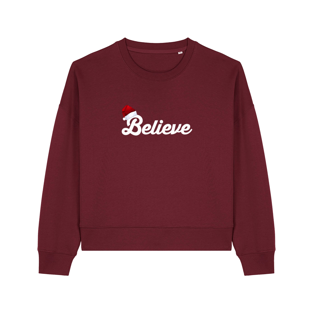 burgundy christmas sweater with the slogan 'believe' and a santa hat on top of the b