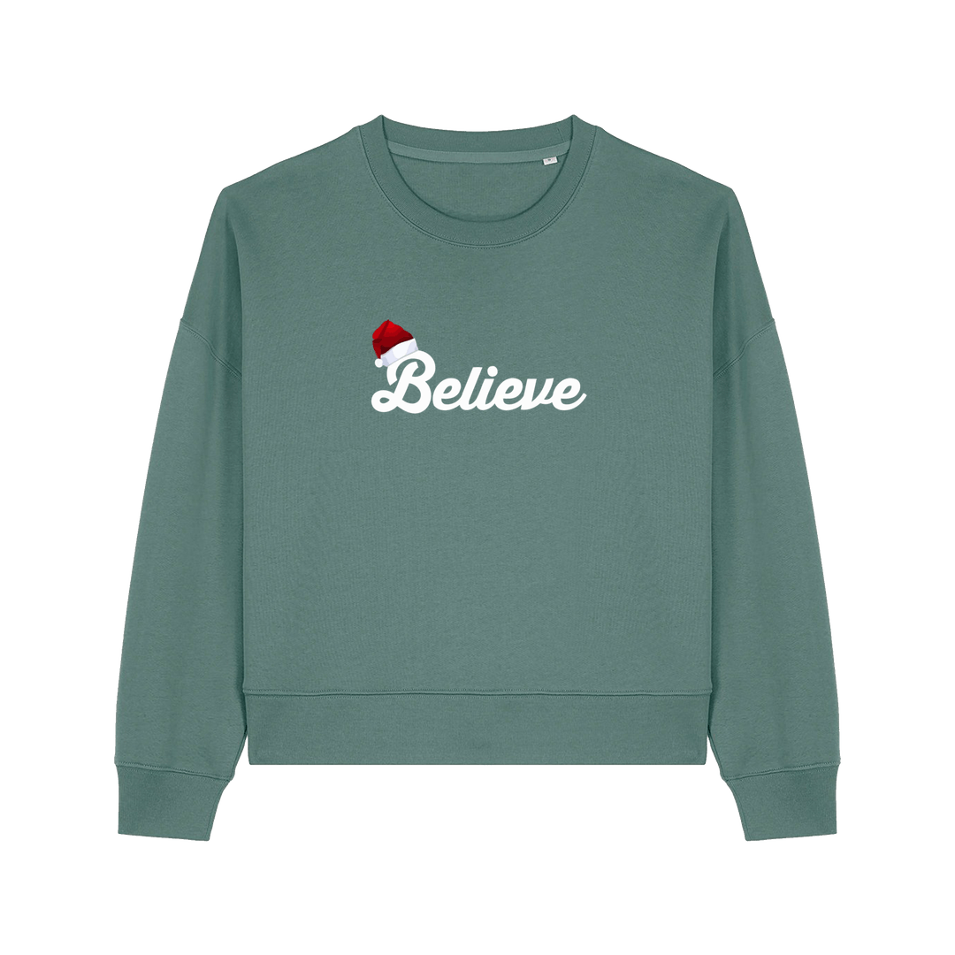 green christmas sweater with the slogan 'believe' and a santa hat on top of the b