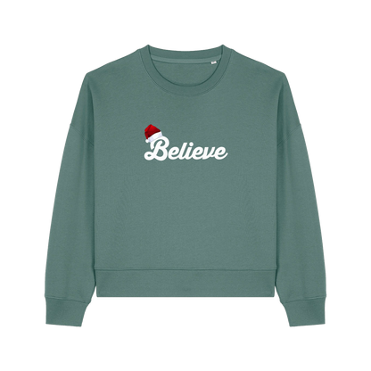 green christmas sweater with the slogan 'believe' and a santa hat on top of the b