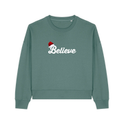 green christmas sweater with the slogan 'believe' and a santa hat on top of the b
