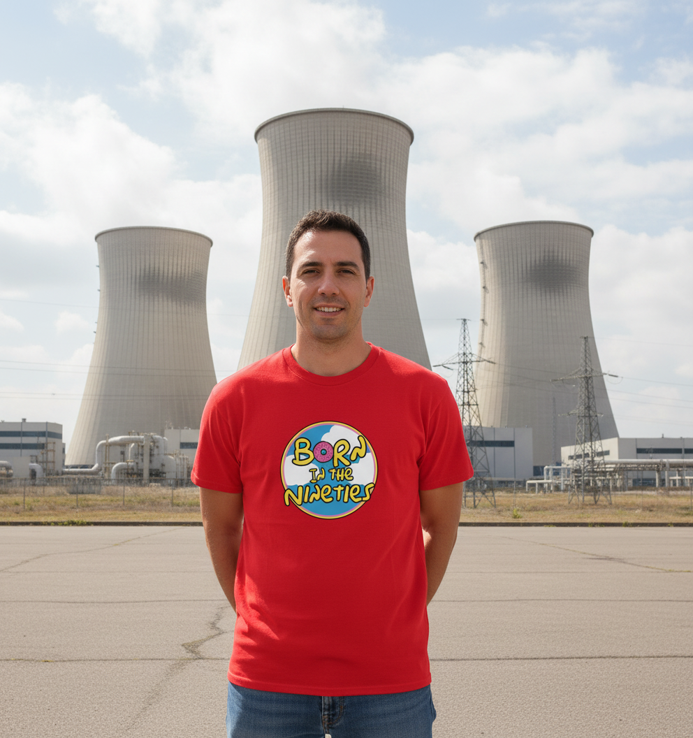 Person wearing a red t-shirt with a colorful graphic design in front of cooling towers.