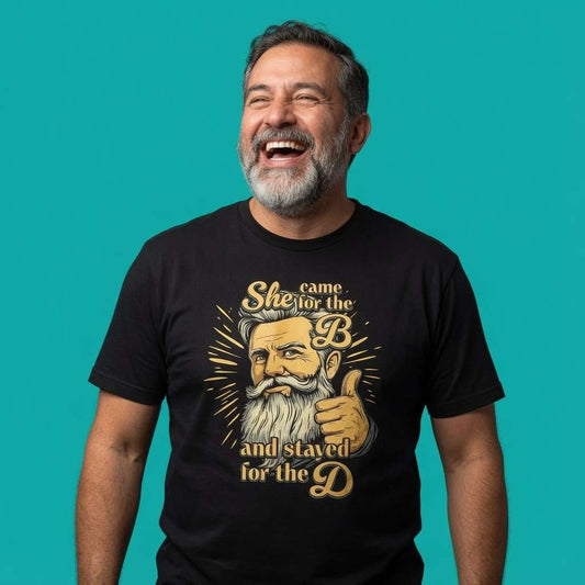 Man laughing with head tilted back while wearing a black She Came for the B and Stayed for the D t-shirt featuring a bearded man giving a thumbs-up, funny graphic design that every cheeky lad will claim