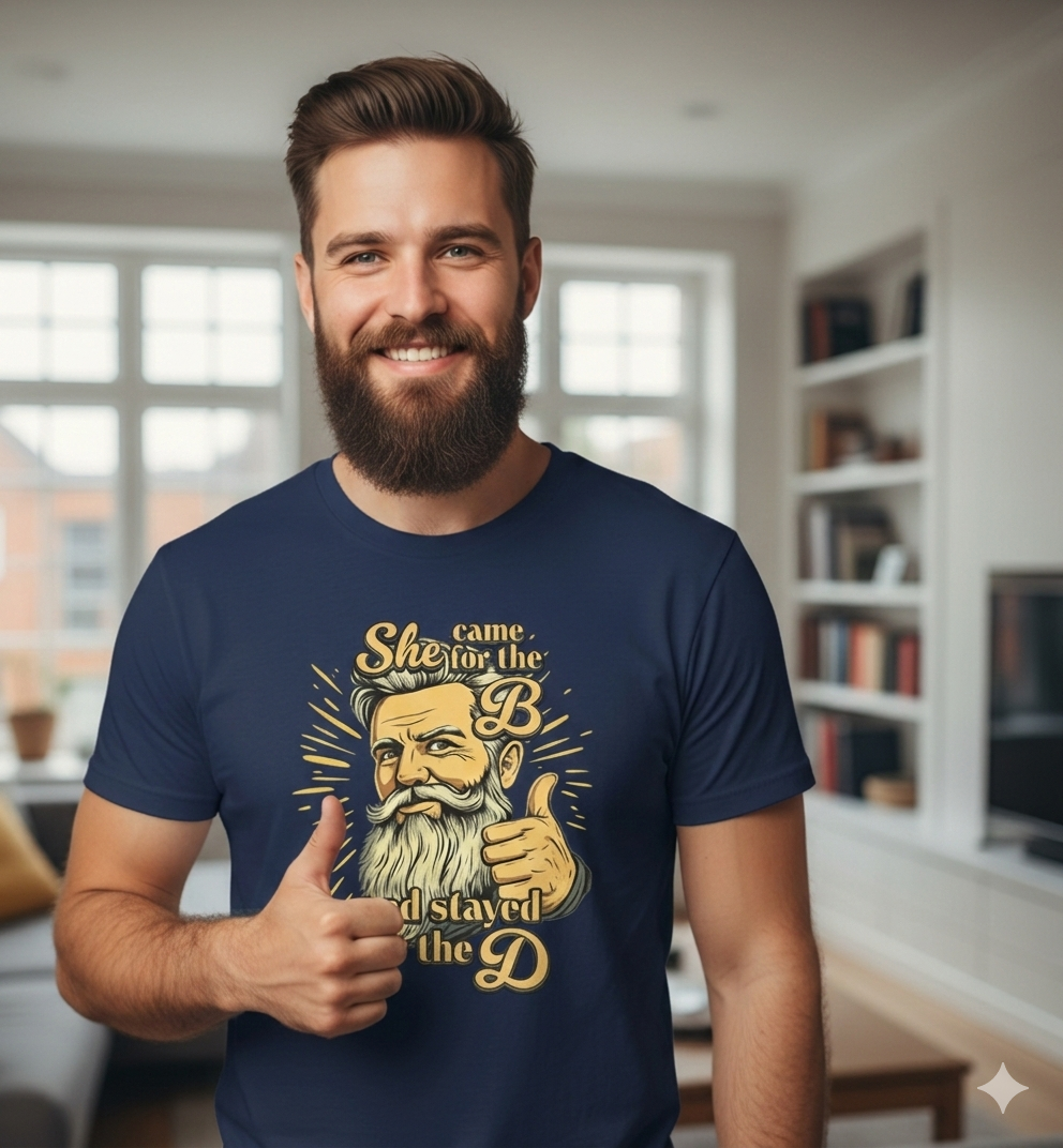 Man wearing a navy blue t-shirt with a graphic design, standing in a room with bookshelves.