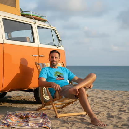 Man sitting on a beach chair next to an orange van with ocean in the background