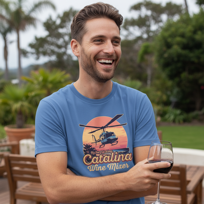 Man wearing a blue t-shirt with a helicopter graphic and 'Catalina Wine Mixer' text, holding a glass of red wine outdoors.
