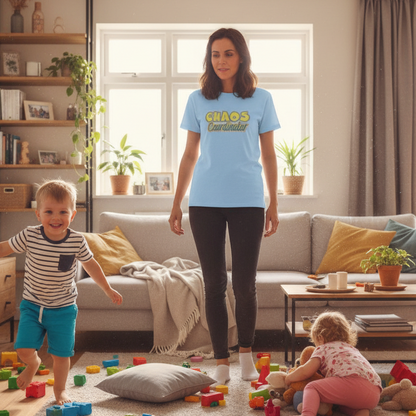 woman wearing a light blue 'chaos coordinator' t-shirt, stood in a living room with two children causing mayhem
