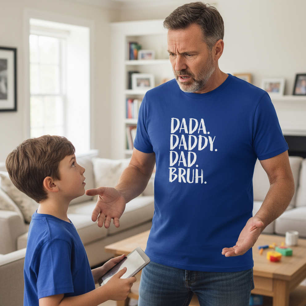 Man and child in a living room with man wearing a blue shirt with 'dada daddy dad bruh'