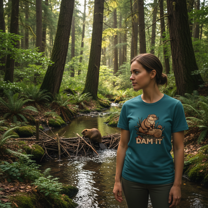 woman wearing a teal coloured t-shirt with the graphic of a beaver, stood in a forest watching a beaver build a dam