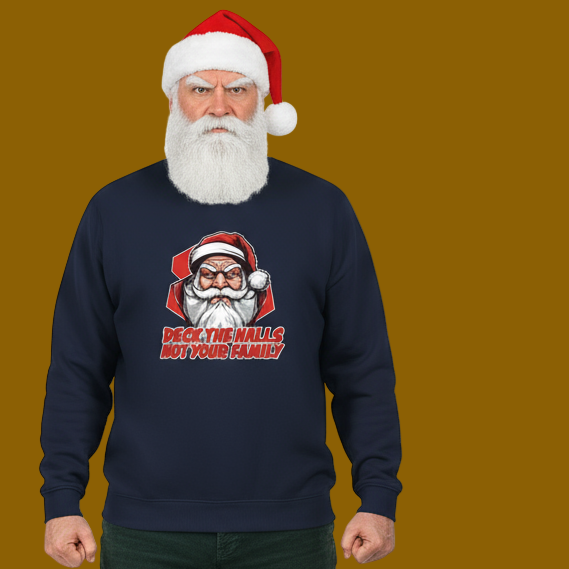 A man wearing a Santa hat and a navy sweatshirt with a Santa print and the words "Deck the Halls, Not Your Family." The background is brown.