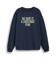 navy christmas jumper with the slogan 'die hard is a christmas film'