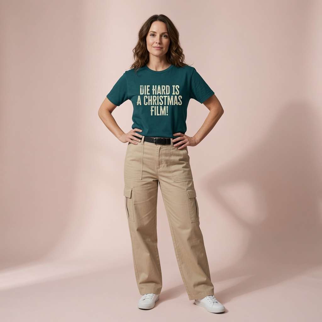Woman in stargazer green Die Hard Is A Christmas Film t-shirt, fun witty Christmas movie debate tee