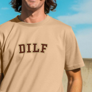 Man wearing a beige dad t-shirt with 'DILF' printed on it against a blue sky.
