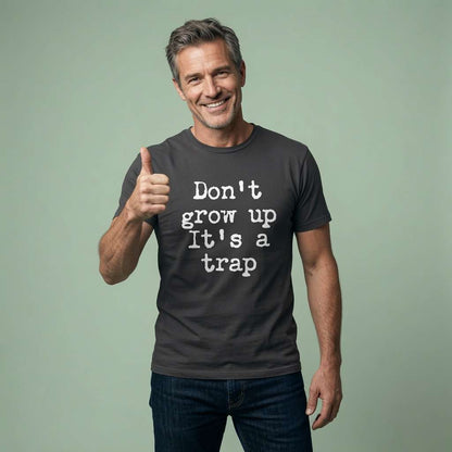 Smiling man giving thumbs up in black Don’t Grow Up It’s a Trap t-shirt, fun age-related slogan