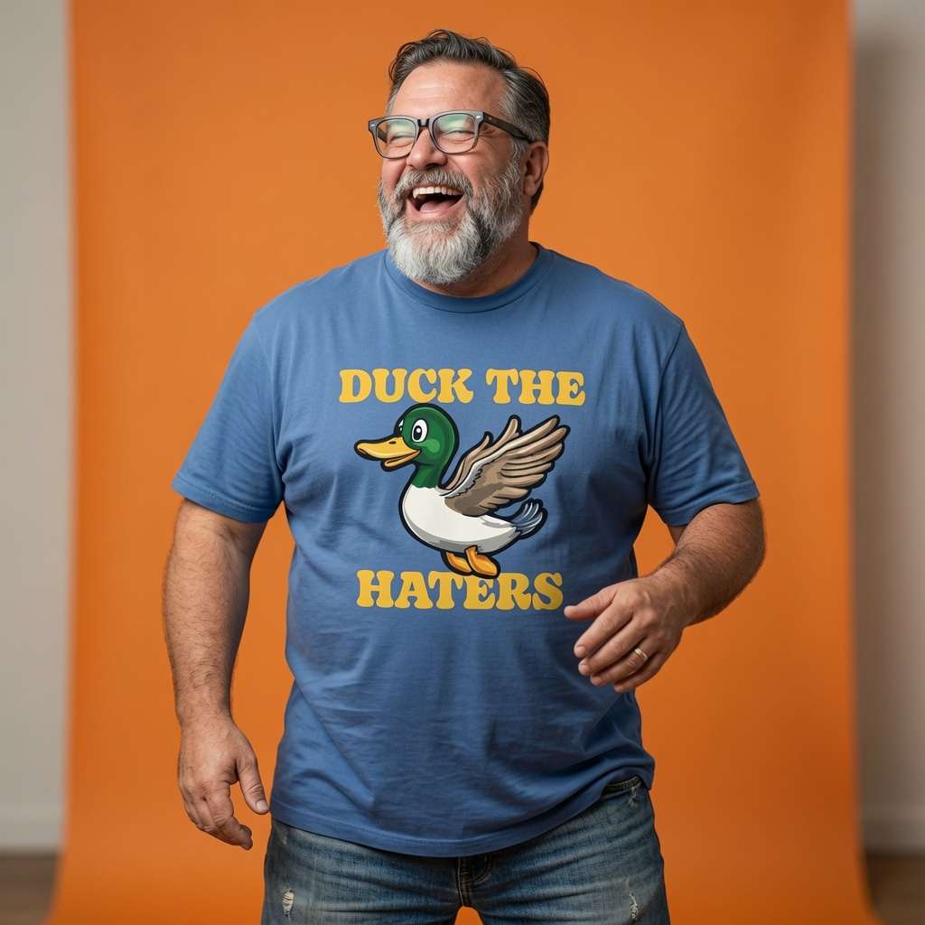 Man laughing with one hand near his hip in a blue Duck The Haters t-shirt, witty mens cheeky duck pun graphic design that every cheeky lad will claim