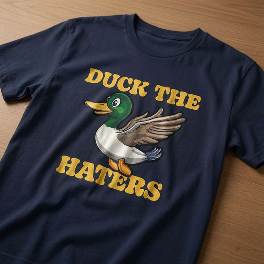 Navy Duck The Haters t-shirt laid flat on a wooden surface showing the full cartoon duck graphic, witty ladies animal pun graphic design
