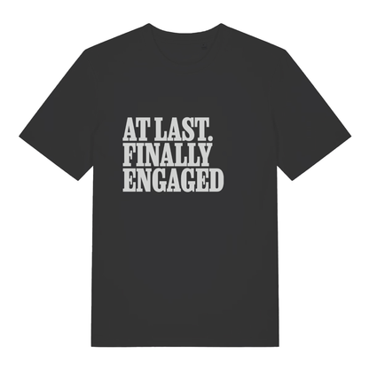 Black women's At Last Finally Engaged T-shirt flat lay with bold white slogan text