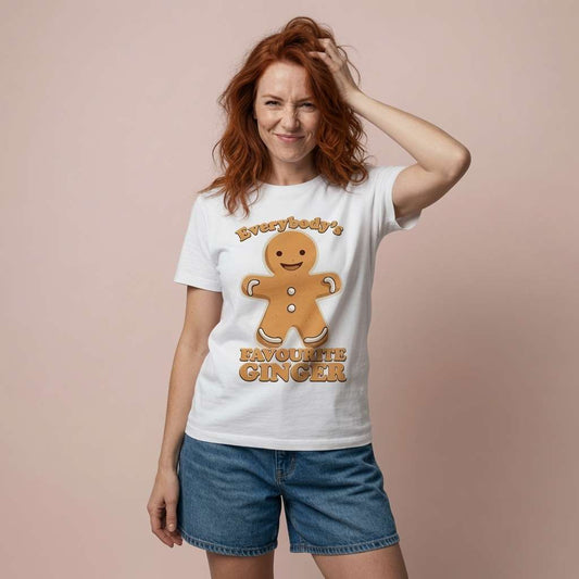 Red-haired woman smiling with hand in hair in white Everybody’s Favourite Ginger t-shirt, fun witty cheeky gingerbread