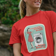 Person wearing a red funny t-shirt with a graphic design featuring a 1950's housewife and funny slogan.