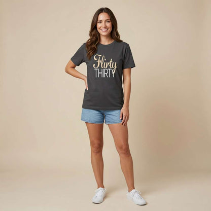 Smiling woman standing with hand on hip in black Flirty Thirty tee, fun ladies 30 slogan