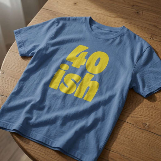 Blue 40 ish t-shirt on wood with bold yellow text, fun ladies 40th birthday slogan