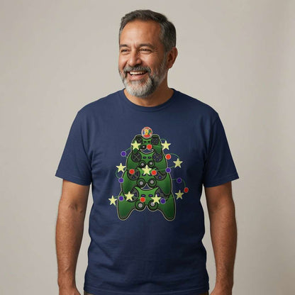 A smiling man with a gray beard wearing a navy blue t-shirt with a green Christmas tree game controller graphic, standing against a plain beige background.
