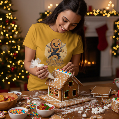 woman building a gingerbread house whilst wearing a t-shirt with a gengerbread man design