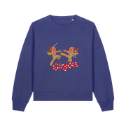 blue christmas sweater with the graphic of two gingerbread men fighting with candy canes and the slogan 'ginjas'