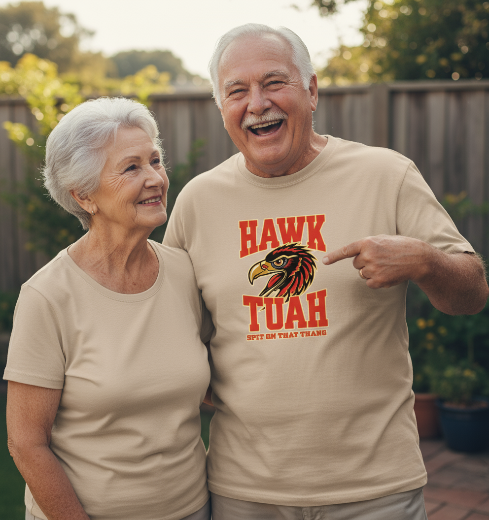 Senior couple standing outdoors, man pointing to a 'Hawk Tuah' t-shirt
