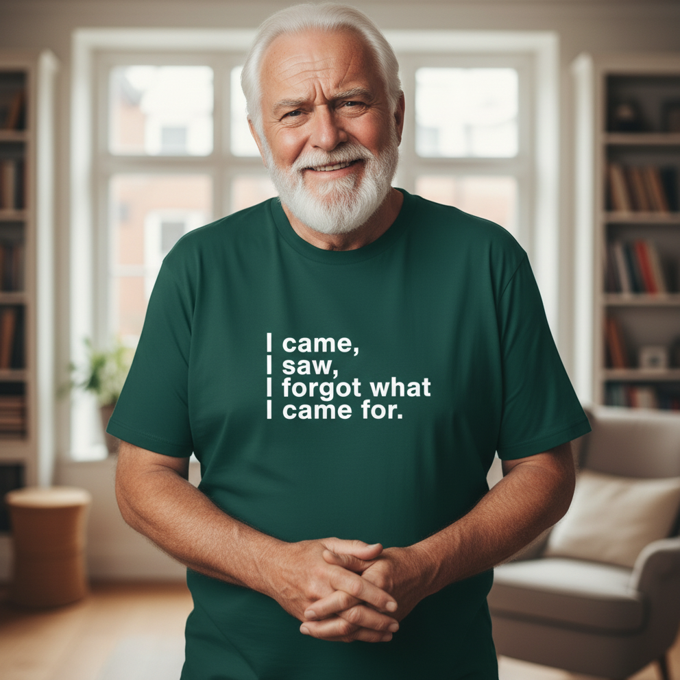 Man wearing a green t-shirt with humorous text in a room with bookshelves.
