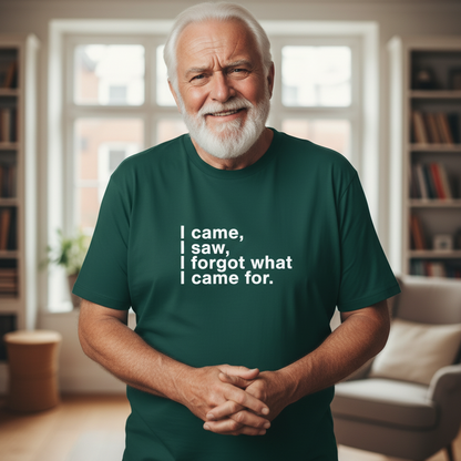 Man wearing a green t-shirt with humorous text in a room with bookshelves.