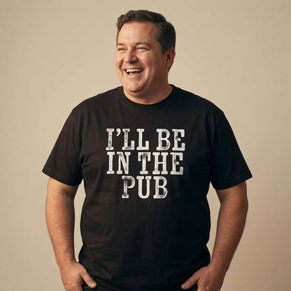 Man laughing with hands in pockets in black I’ll Be in the Pub tee, mens funny pub banter