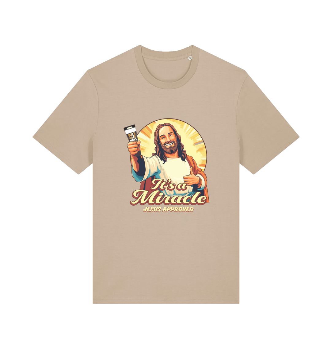 beige funny jesus t-shirt with the graphic of jesus holding a tube of no more nails and the slogan 'it's a miracle jesus approved'