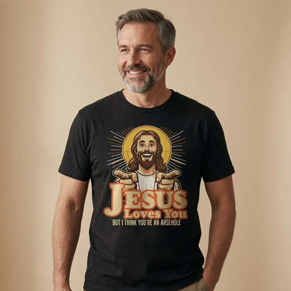 Grey-haired man smiling in black Jesus Loves You But I Think You’re an Arsehole tee with pointing Jesus design, funny offensive jesus graphic