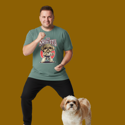 Man wearing a green t-shirt with a dog graphic and text, standing next to a small dog on a mustard yellow background.