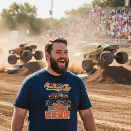 Man wearing a navy blue t-shirt with a graphic design of a monster truck in an outdoor setting with spectators and monster trucks.