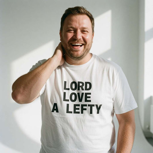 Man laughing with hand behind neck in white Lord Love a Lefty t-shirt, humorous mens memorable slogan