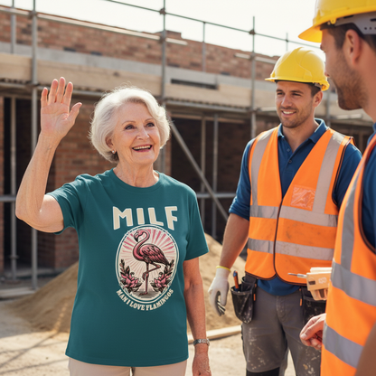 Woman in teal shirt with flamingo graphic and 'MILF' text on a construction site with two men in safety vests.