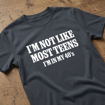 Ink grey I’m Not Like Most Teens I’m In My 40’s t-shirt on wood, funny ladies relatable slogan