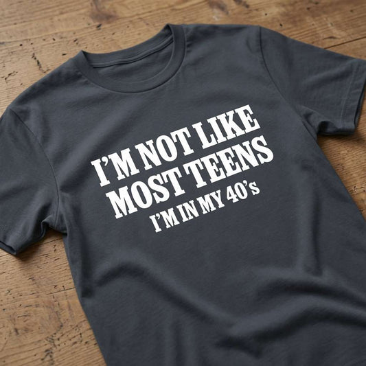 Ink grey I’m Not Like Most Teens I’m In My 40’s t-shirt on wood, funny ladies relatable slogan