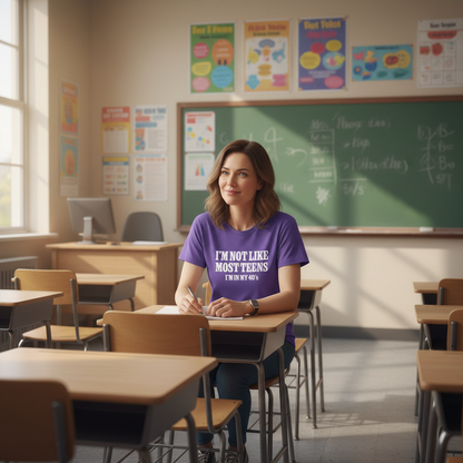 Woman sitting at a desk in a classroom wearing a purple t-shirt.